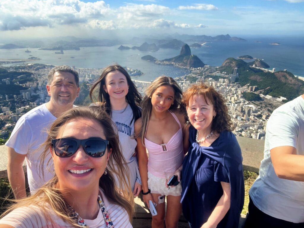 Happy family visiting Christ the Redeemer with Sugarloaf Mountain in the background